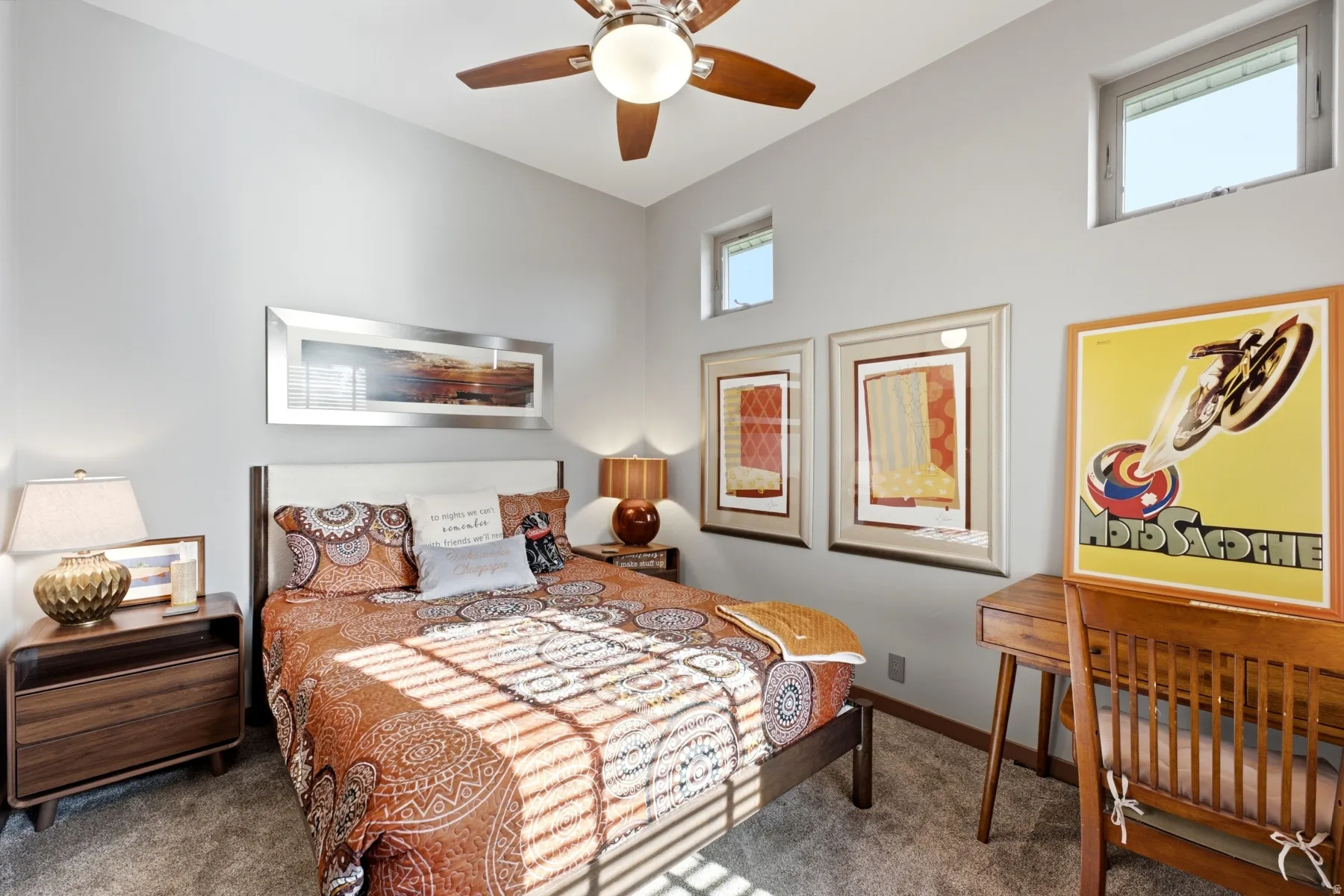 Vaulted ceiling with a ceiling fan, multiple windows at varying heights, and neutral wall tones