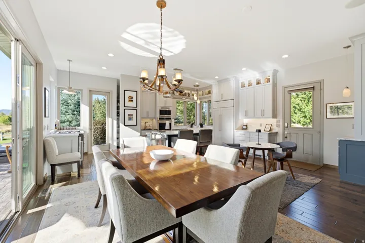 Hardwood flooring throughout, with a wood-finish dining table and a multi-light chandelier