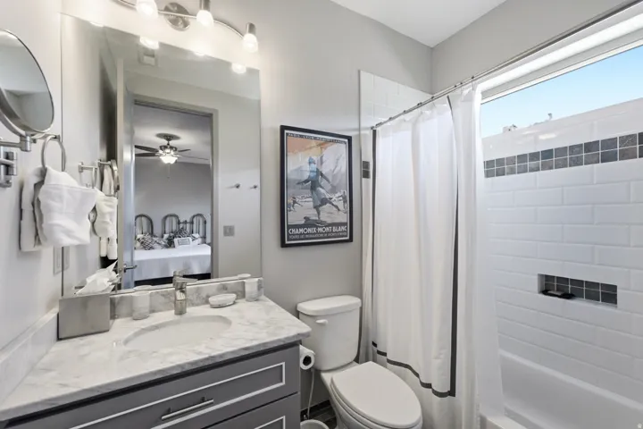 Bathroom featuring a single vanity with a stone countertop, a rectangular sink, and a framed mirror