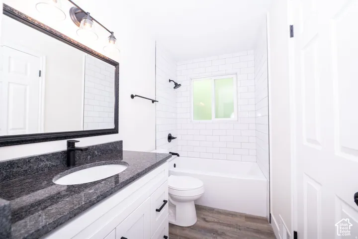 Dark stone countertop with an undermount sink, matte black faucet, and white shaker-style cabinetry