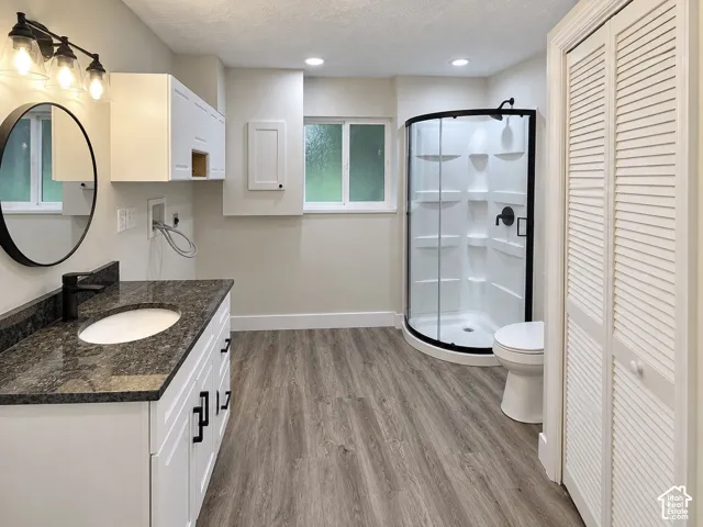 Bathroom featuring a white vanity with a dark stone countertop, an integrated sink, and matte black hardware
