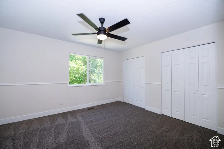 Recessed lighting, ceiling fan, bi-fold closet doors, wall paneling, and carpet flooring
