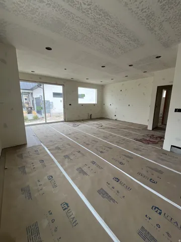 Spacious room with multiple recessed ceiling lights, large sliding glass door, and an additional window