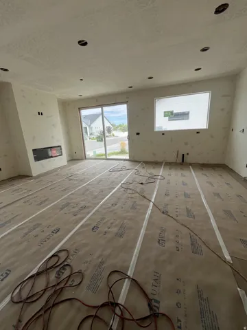 Recessed ceiling lighting, built-in fireplace, sliding glass door, fixed pane window, and unfinished walls