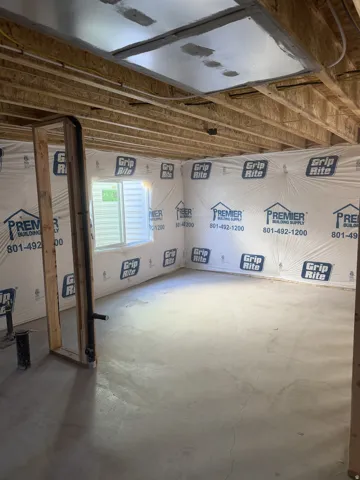 Unfinished basement space featuring exposed wood joists and concrete flooring