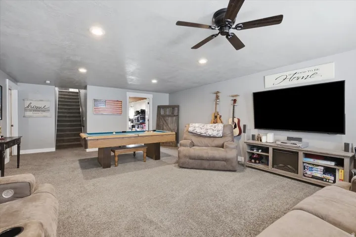 Recessed lighting, wood-finish ceiling fan, carpeted flooring, and a barn door