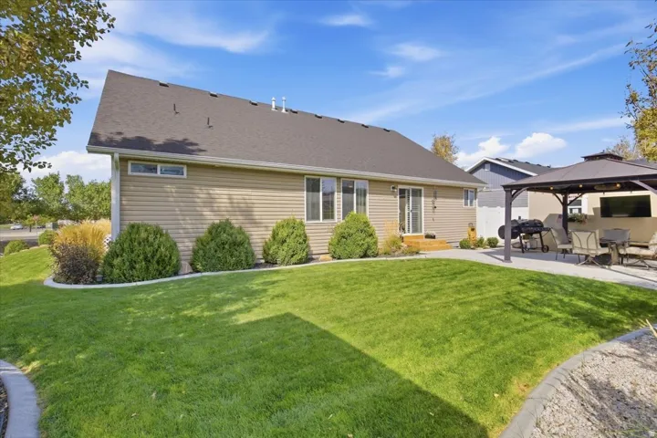 Expansive lawn with concrete edging, a rear deck, and mature landscaping