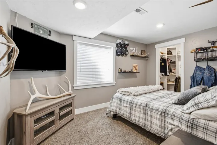 Recessed lighting, neutral-toned walls, and a built-in closet with shelving