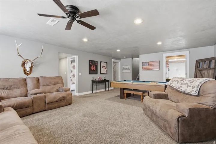 Spacious room featuring neutral carpeting, recessed lighting, and a ceiling fan