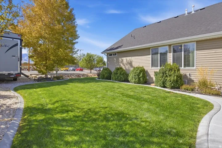 Manicured lawn with a concrete pathway and established shrubs
