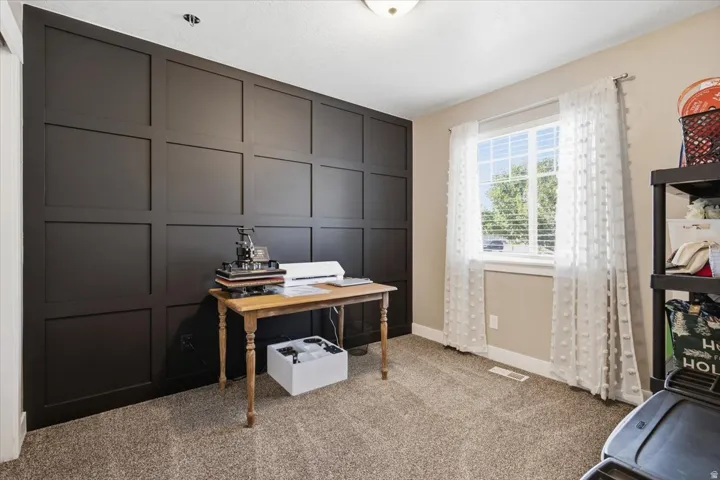 Accent wall with paneling, window with blinds, and carpeted flooring