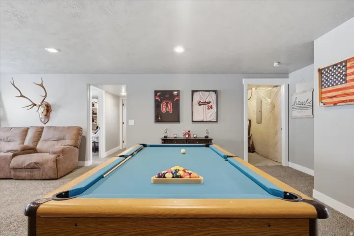 Recessed lighting illuminates the carpeted floor and light grey walls