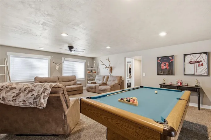 Spacious room featuring a billiards table, recessed lighting, ceiling fan, and two windows with blinds