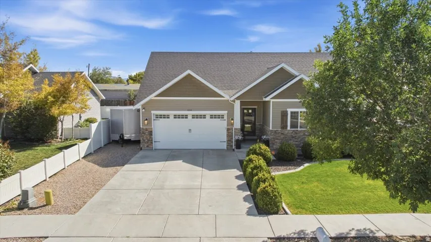 Ranch-style exterior with stone and siding accents, an attached two-car garage, and a concrete driveway