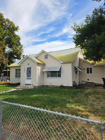 Siding exterior with a metal roof and chain-link fence