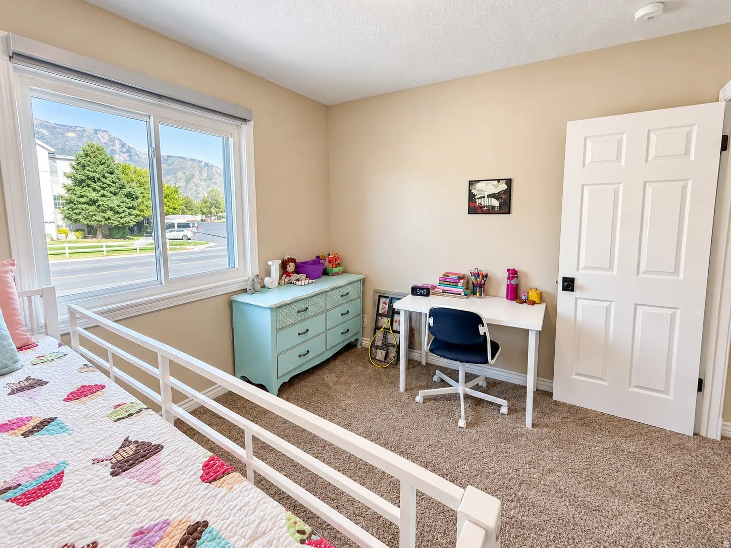 Carpeted room featuring a double-pane window, mountain backdrop, neutral wall tones, and a paneled interior door