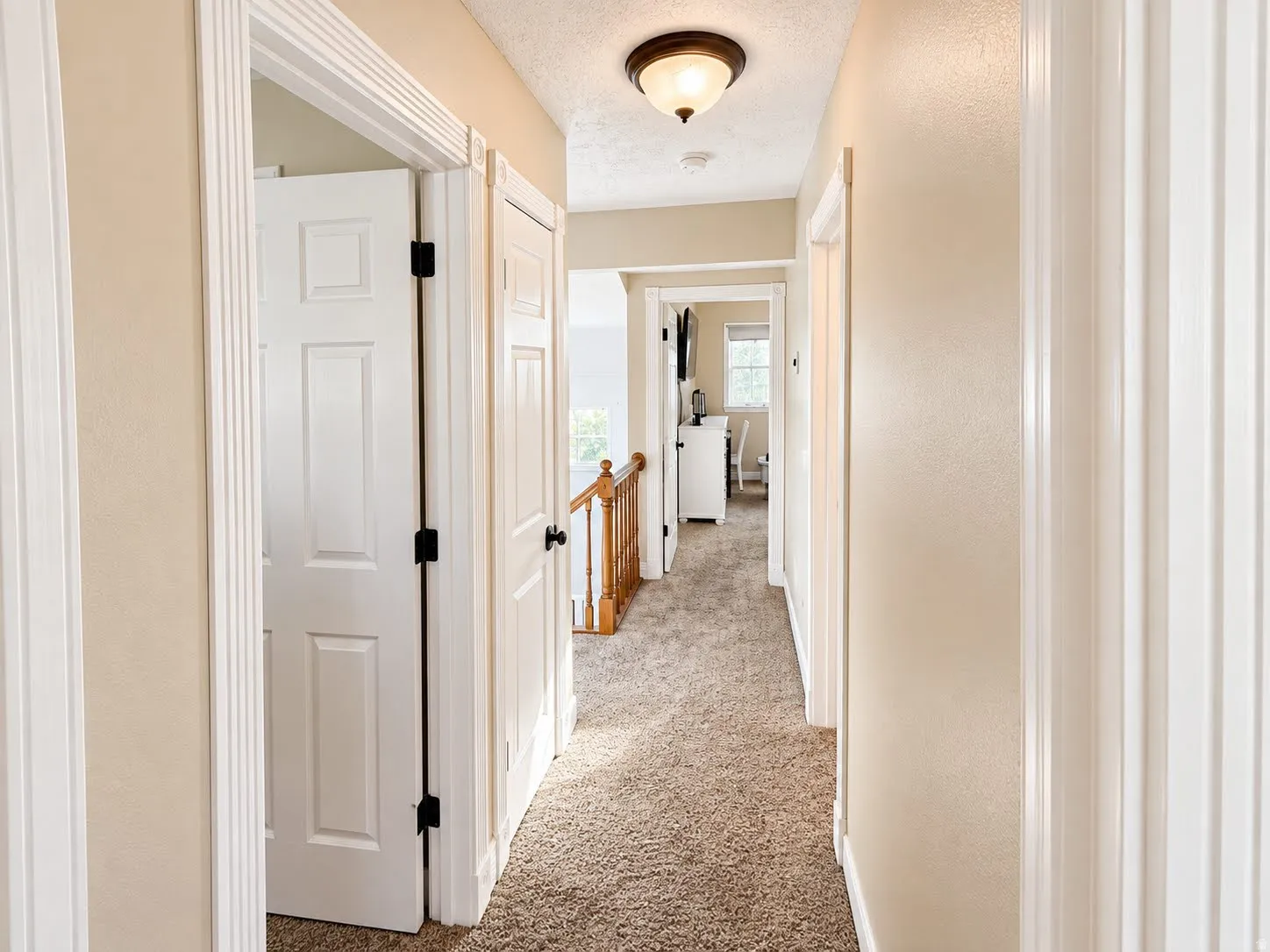 Neutral-toned walls complement the carpeted hallway