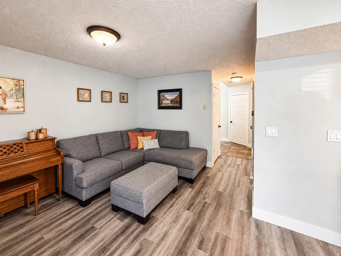 Wood-finish flooring throughout, light-toned walls, and recessed lighting fixtures