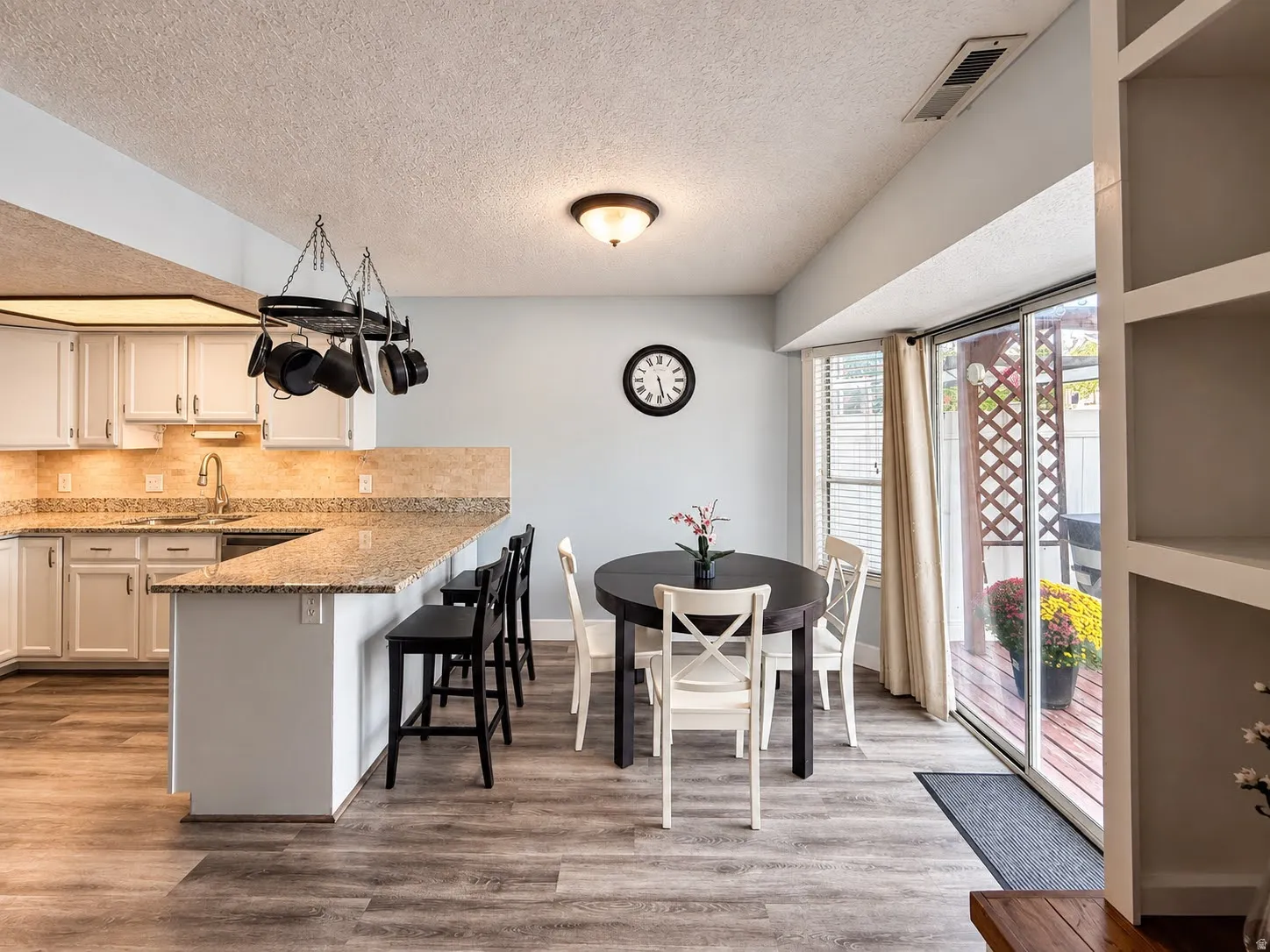 Kitchen featuring white cabinetry, granite countertops, and wood-finish flooring