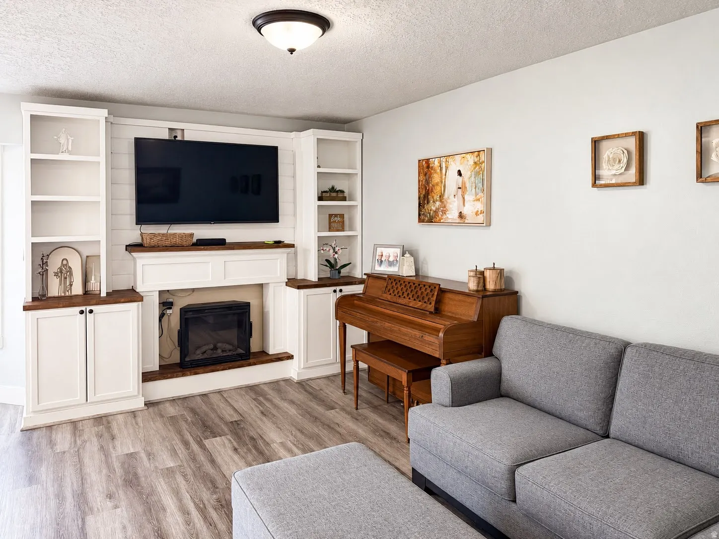 Built-in entertainment center featuring open shelving, base cabinetry, and a fireplace surround