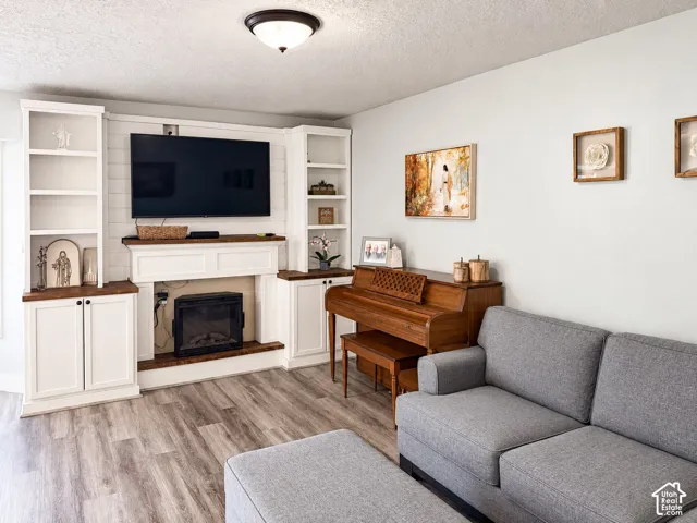 Built-in entertainment center featuring open shelving, base cabinetry, and a fireplace surround
