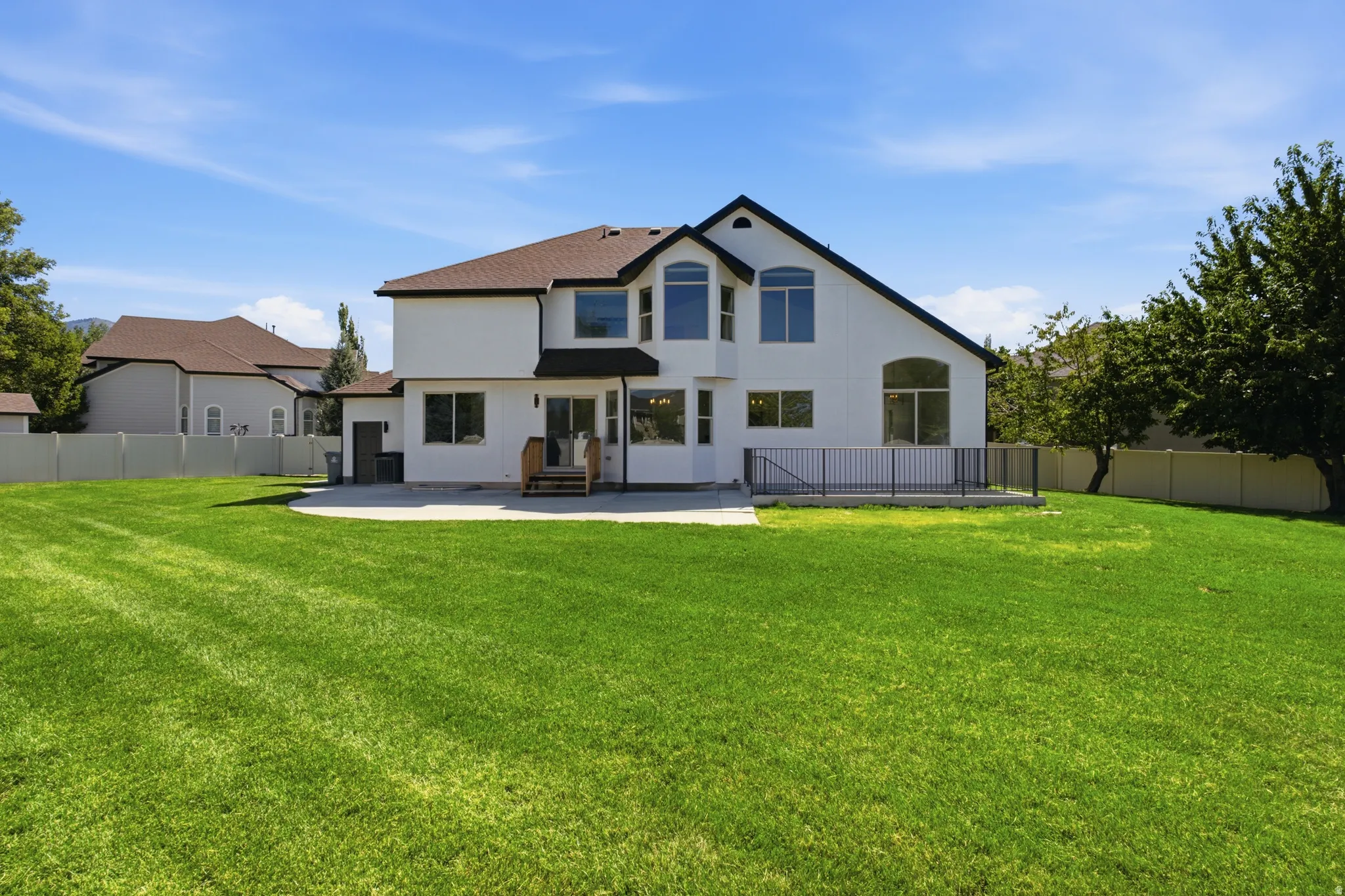 Expansive manicured lawn with a white privacy fence