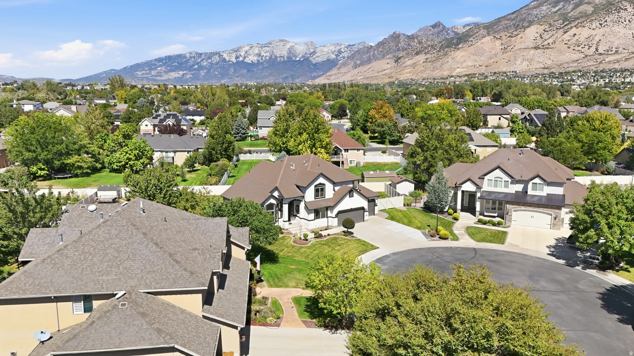 Mountainous backdrop with established neighborhood, mature trees, cul-de-sac street, and well-maintained properties