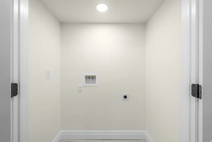 Dedicated utility space with flush-mount lighting, appliance hookups, and neutral wall tones
