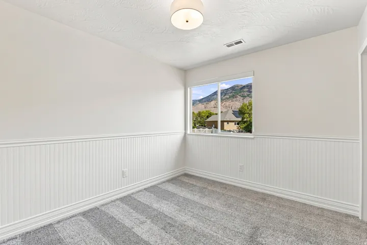 White beadboard wainscoting, neutral walls, and a contemporary ceiling light fixture