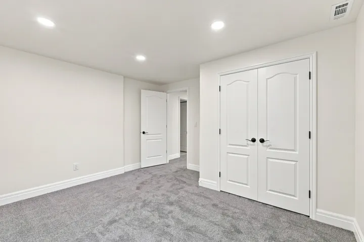 Recessed lighting, plush carpeting, white interior doors, and matte black door hardware