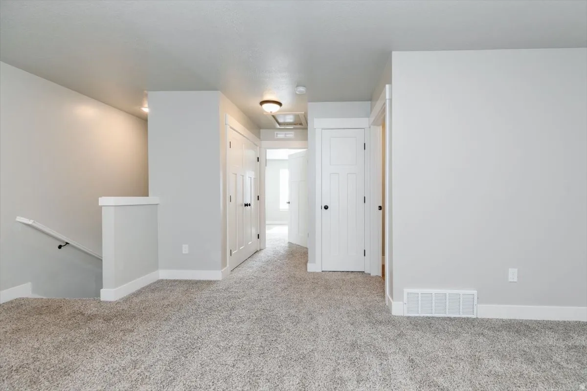 Plush carpeting, white trim, recessed lighting, and panel doors