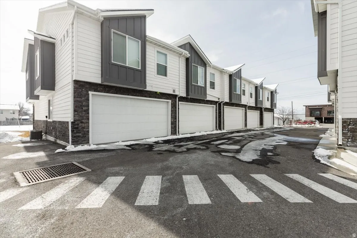 Contemporary townhome exterior with white siding and dark grey accent panels