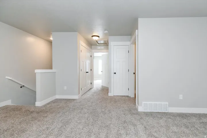 Plush carpeting, white trim, recessed lighting, and panel doors