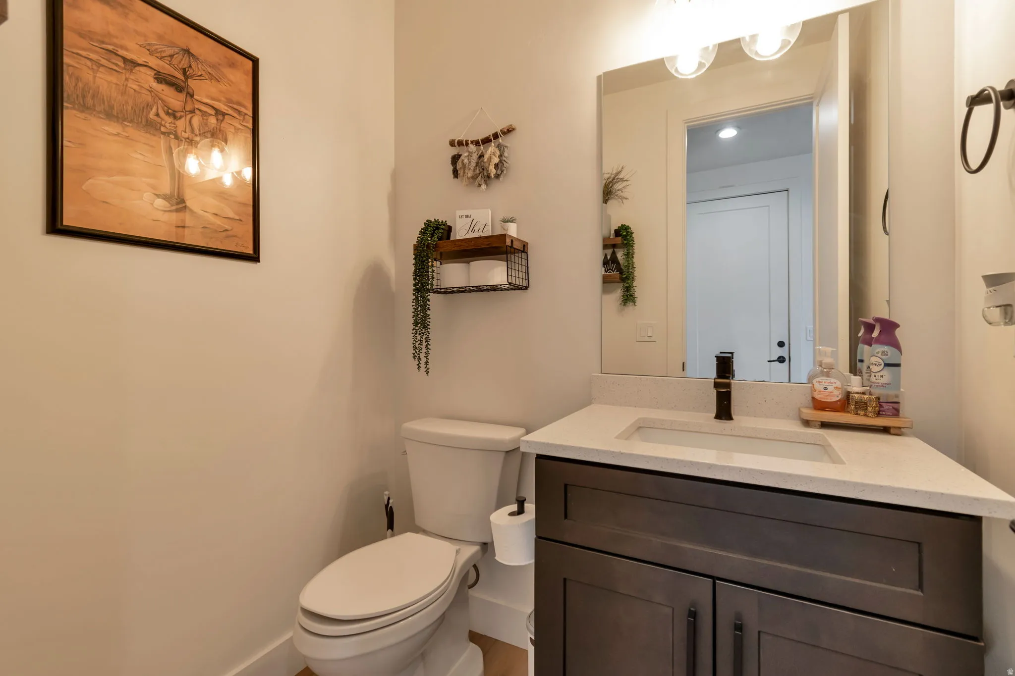 Vanity with a light-toned countertop, rectangular undermount sink, and dark bronze faucet