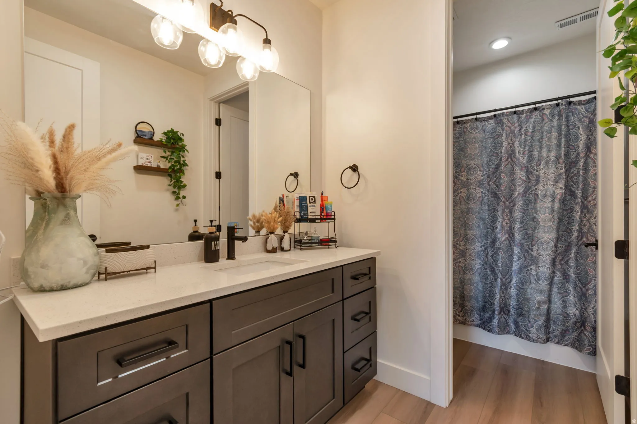 White countertop vanity with dark cabinetry and black hardware