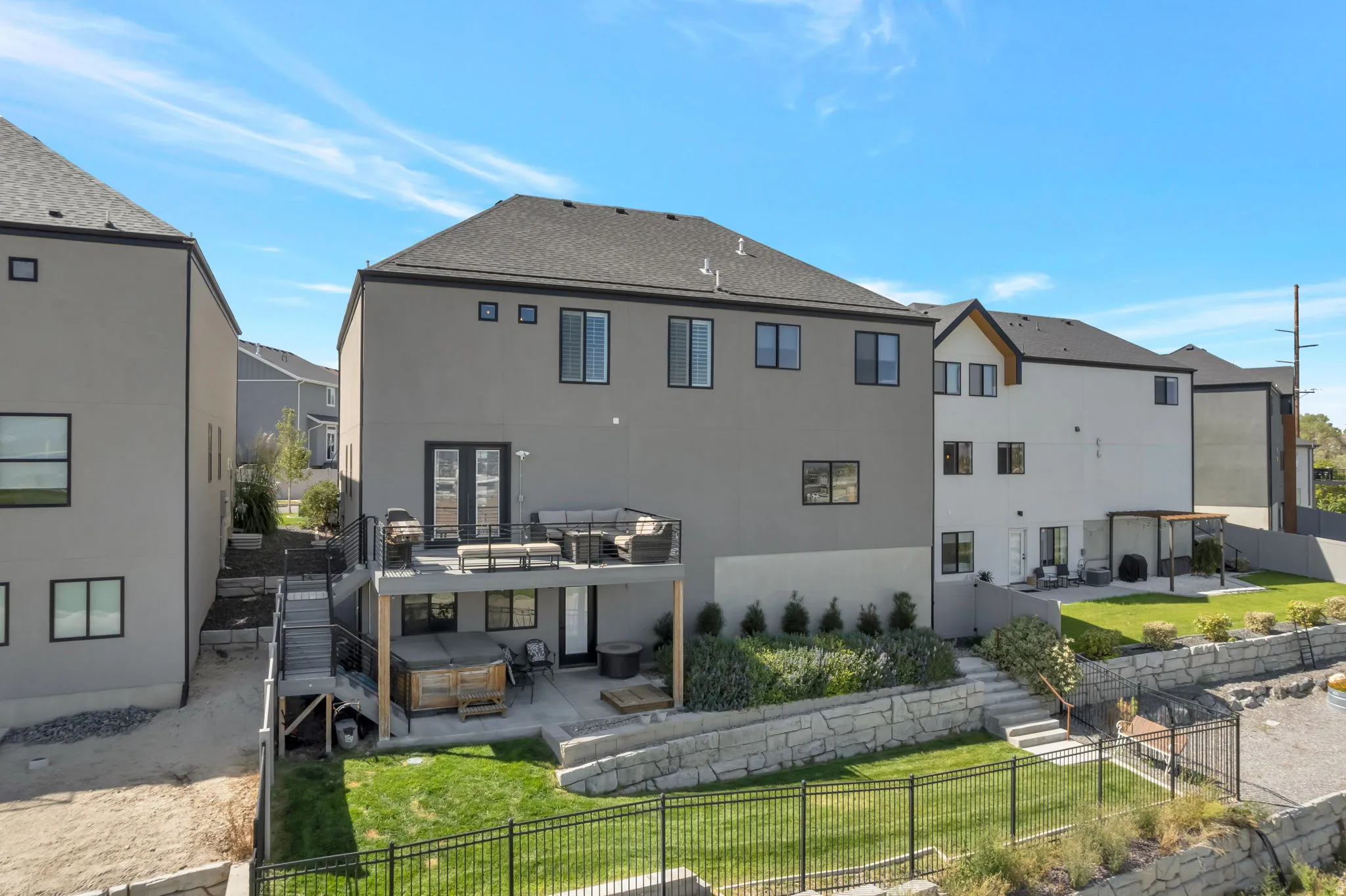 Multi-level exterior with a deck, patio, and terraced landscaping