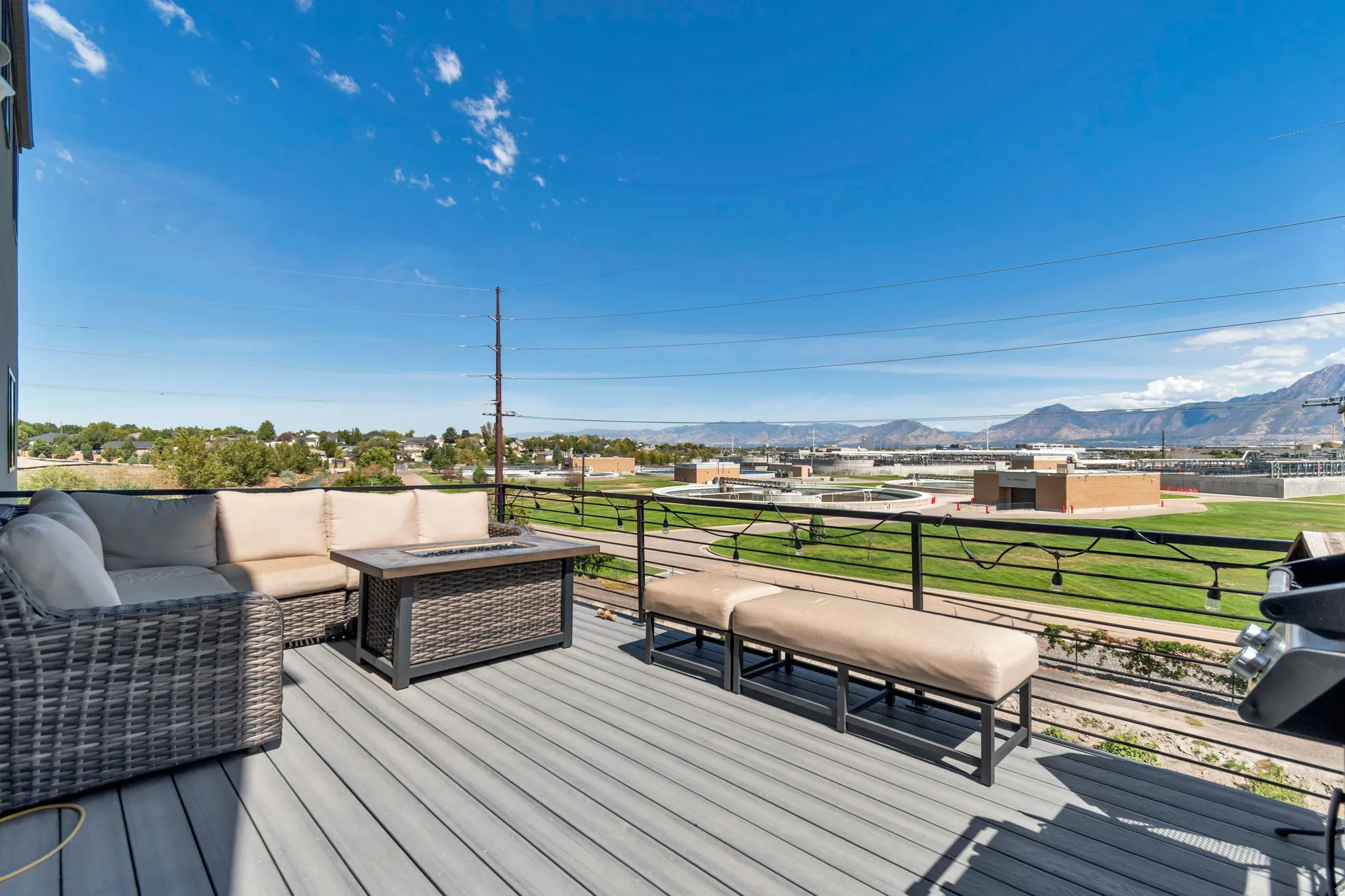Spacious outdoor deck featuring composite decking, black metal railings, and mountain scenery