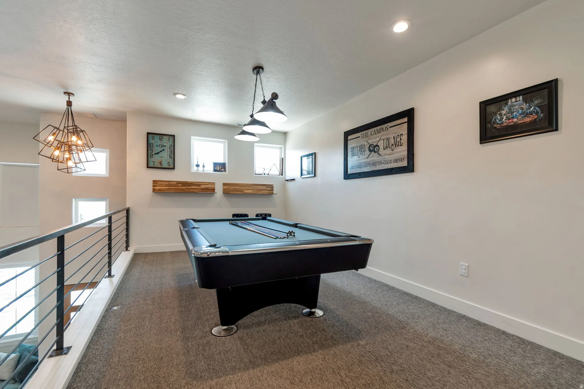 Loft space featuring carpeted flooring, a black metal railing, recessed lighting, and multiple windows