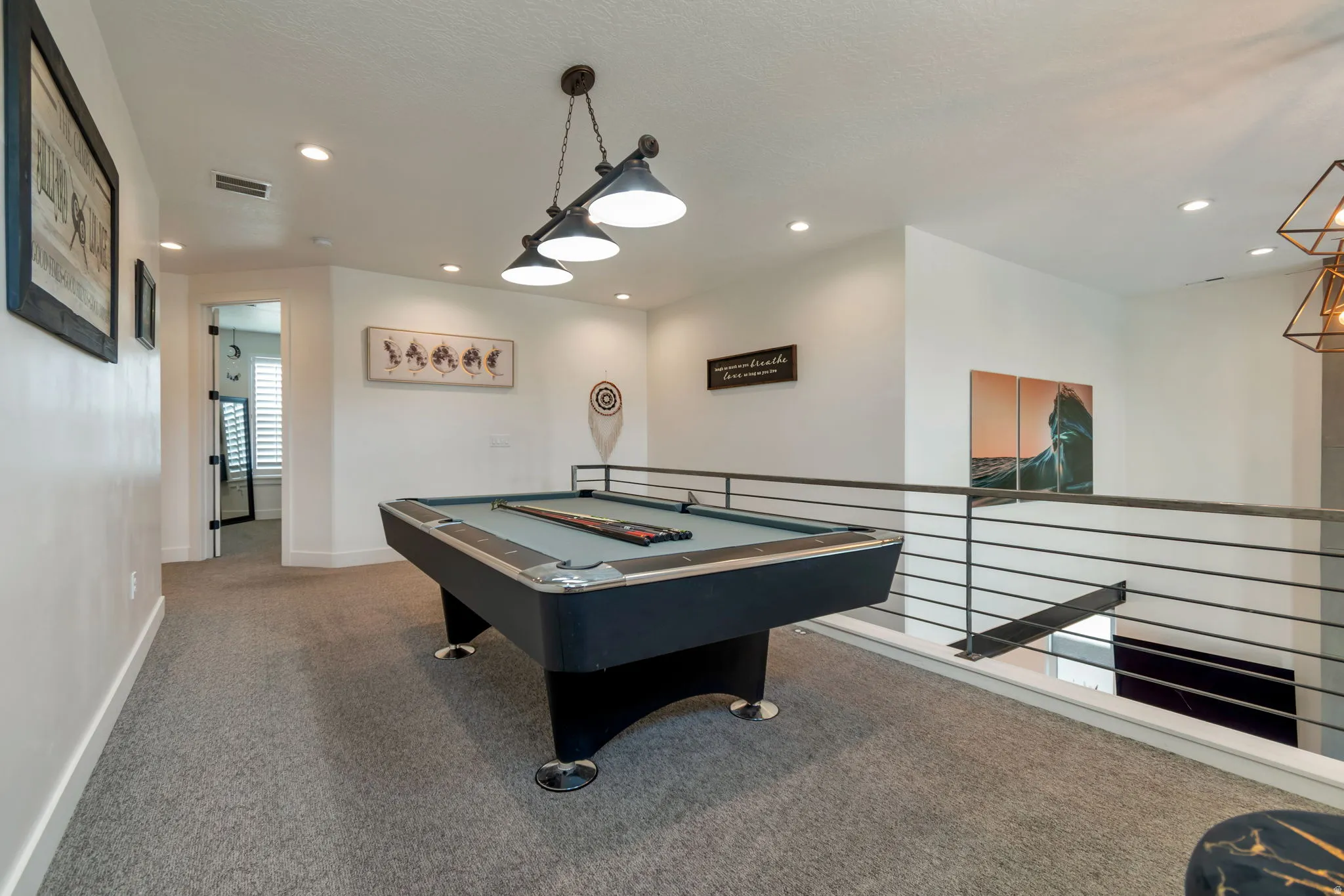 Upper-level loft with recessed lighting and a built-in pool table