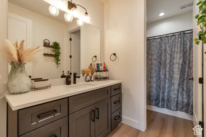 White countertop vanity with dark cabinetry and black hardware