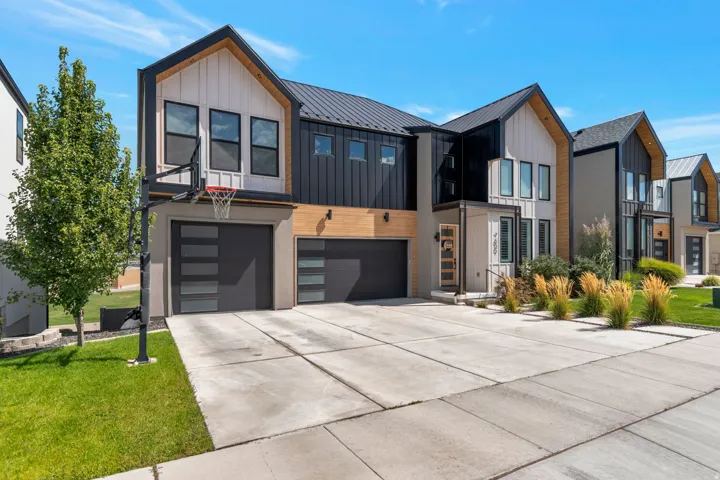 Modern architectural facade featuring vertical siding, a metal roof, and a two-car garage
