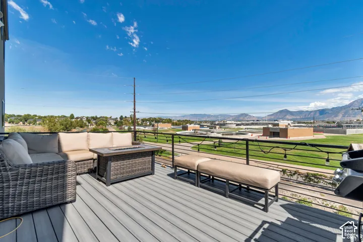 Spacious outdoor deck featuring composite decking, black metal railings, and mountain scenery