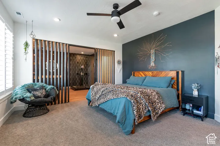 Spacious room with carpet flooring, a dark accent wall, and a ceiling fan