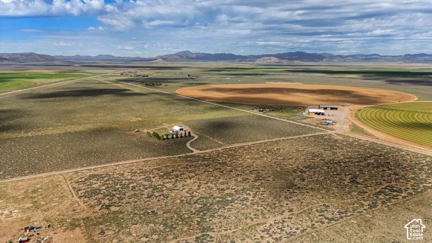 Expansive agricultural property featuring multiple structures, cultivated fields, and extensive open land