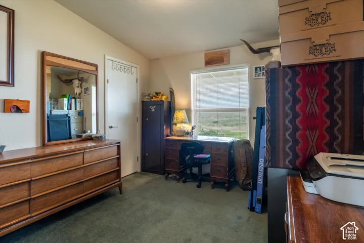 Carpeted room featuring a white door, a single window, and a sloped ceiling