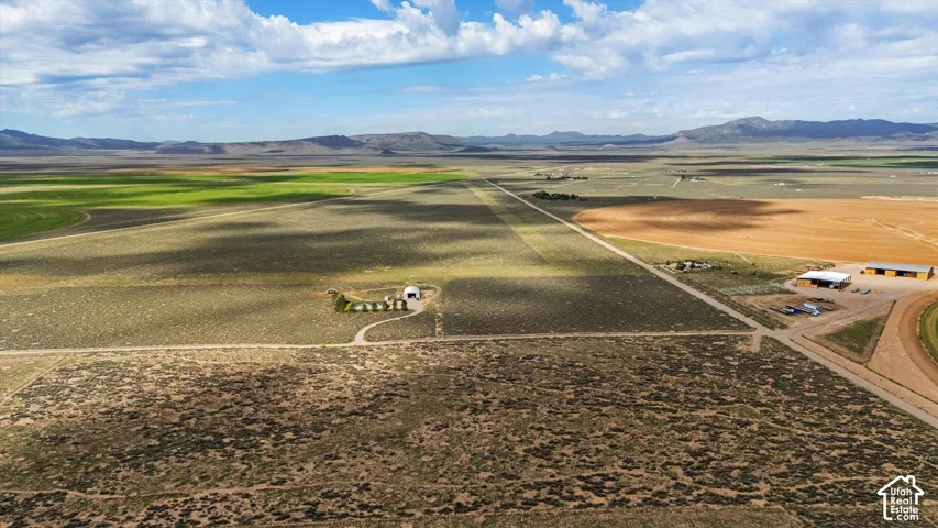 Expansive land parcel with a private airstrip, multiple outbuildings, and cultivated fields