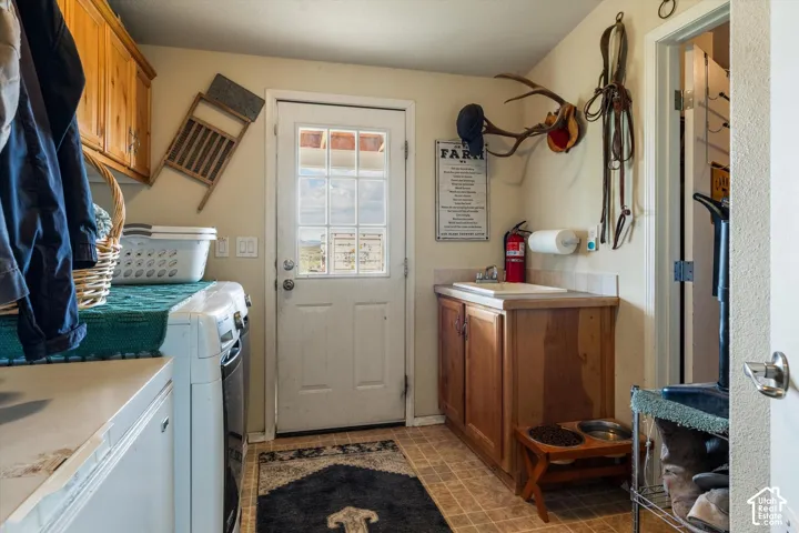 Upper wood cabinetry, vinyl flooring, wood-finish lower cabinetry with integrated sink, and an exterior door with glass panels