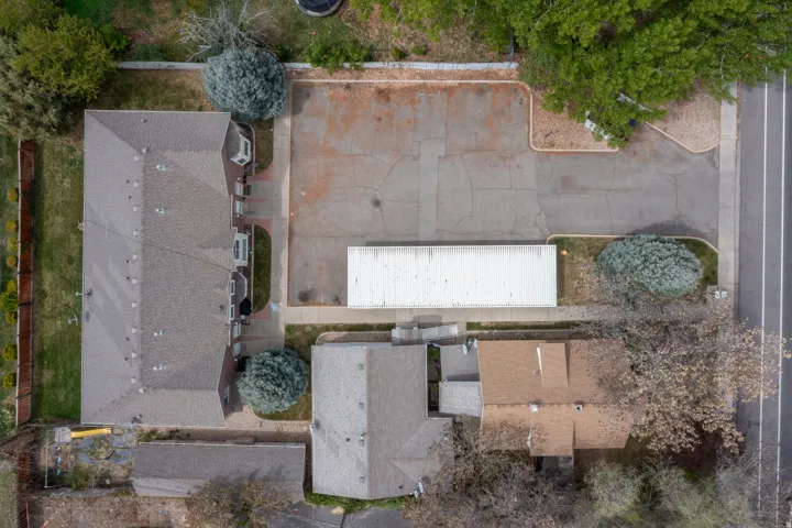 Expansive property featuring multiple structures, paved parking areas, and mature landscaping