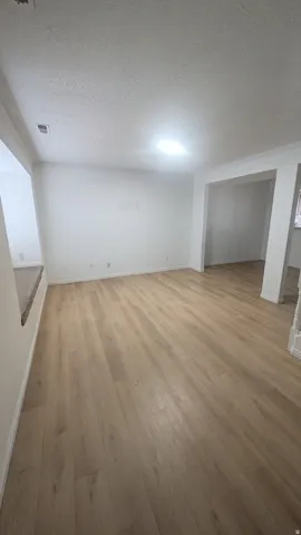 Wood-finish flooring throughout, white wall finishes, built-in window seating, and recessed lighting