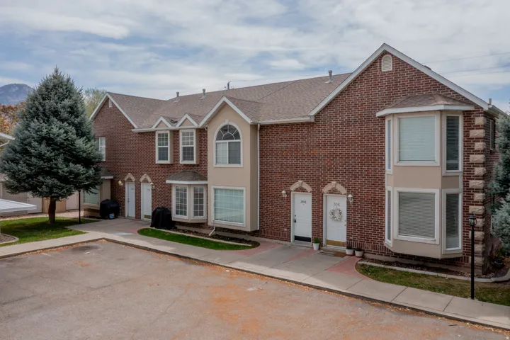 Brick exterior with multiple gabled roofs, bay windows, and arched window features